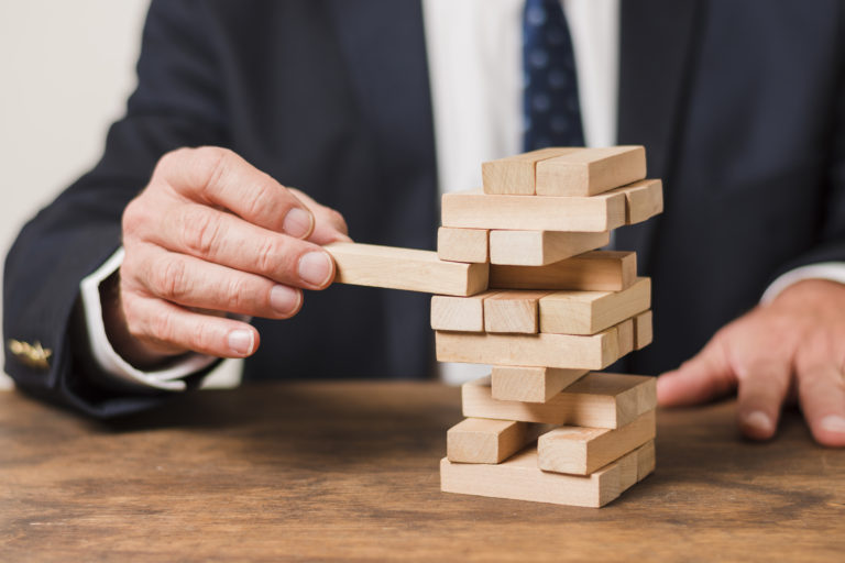 empresario jugando jenga riesgos